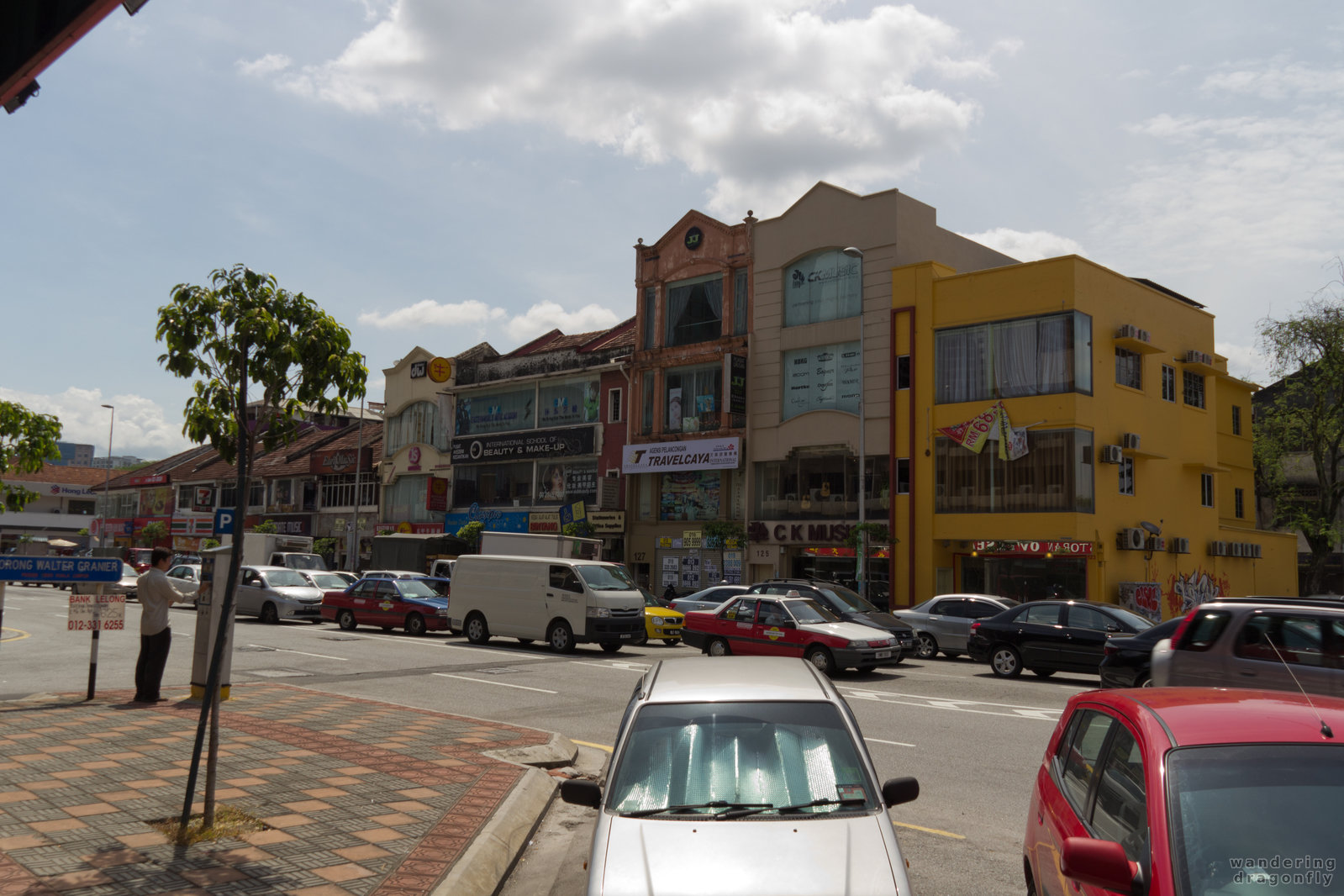 Rush hours on an otherwise quiet street -- building, car, traffic jam