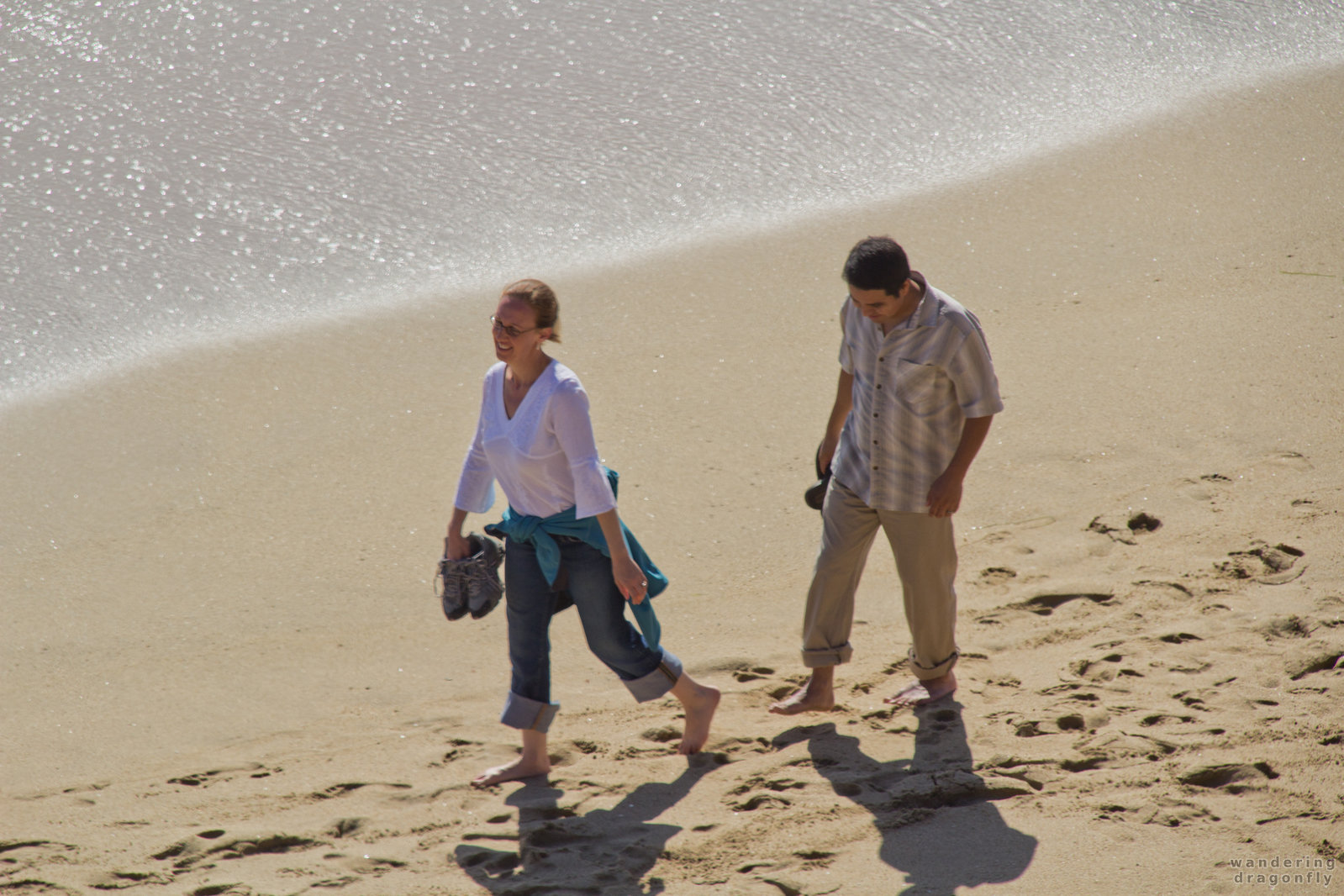 Young couple walks in the sand -- beach, ocean, sand, walking, young couple