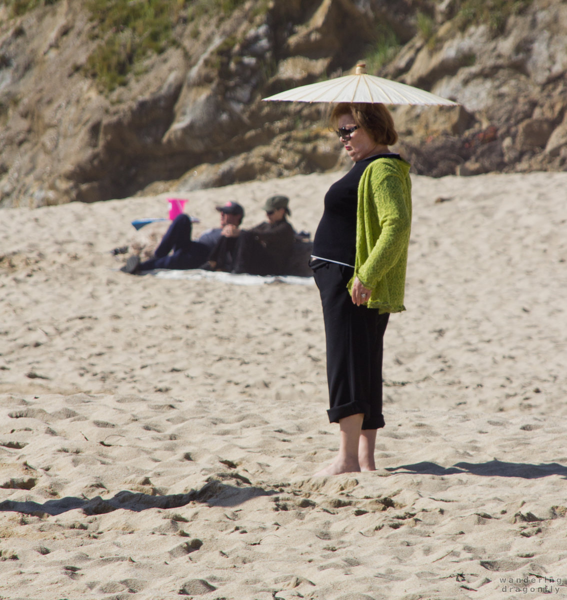 Every shadow counts -- sand, umbrella, woman
