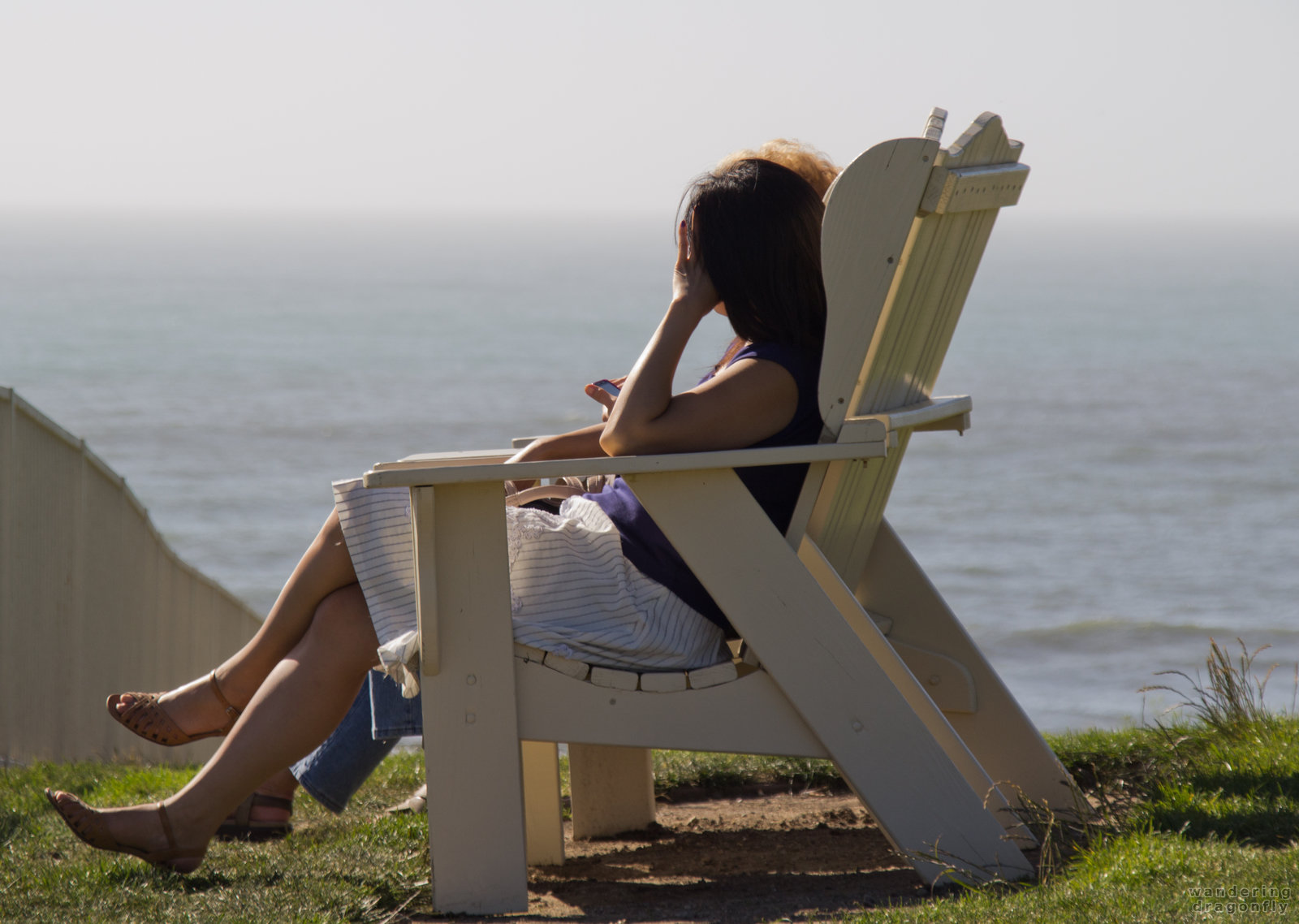 Camera-shy woman enjoys the afternoon sunshine -- chair, ocean, sitting, woman