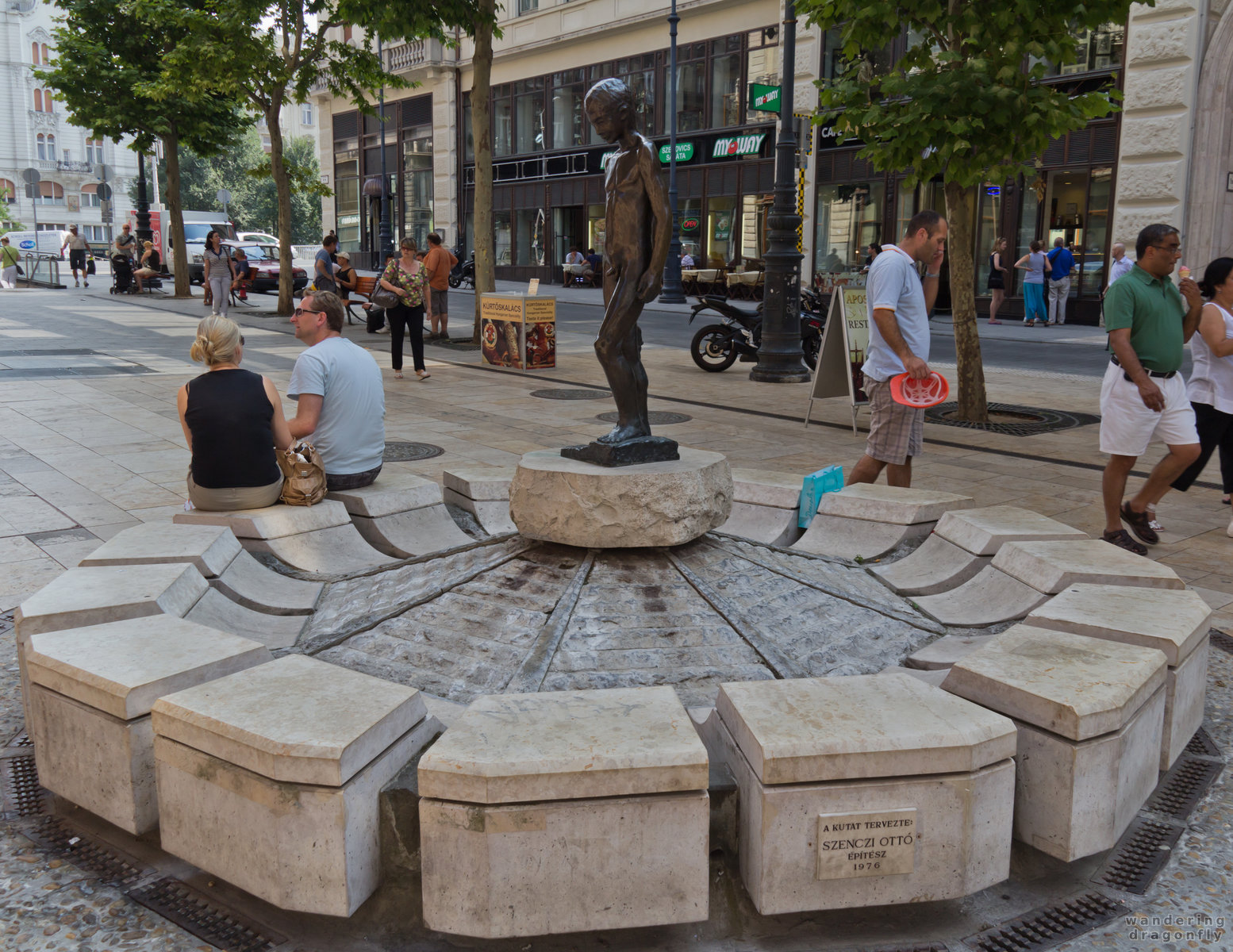 Statue of a young boy -- statue, street, tourist, well