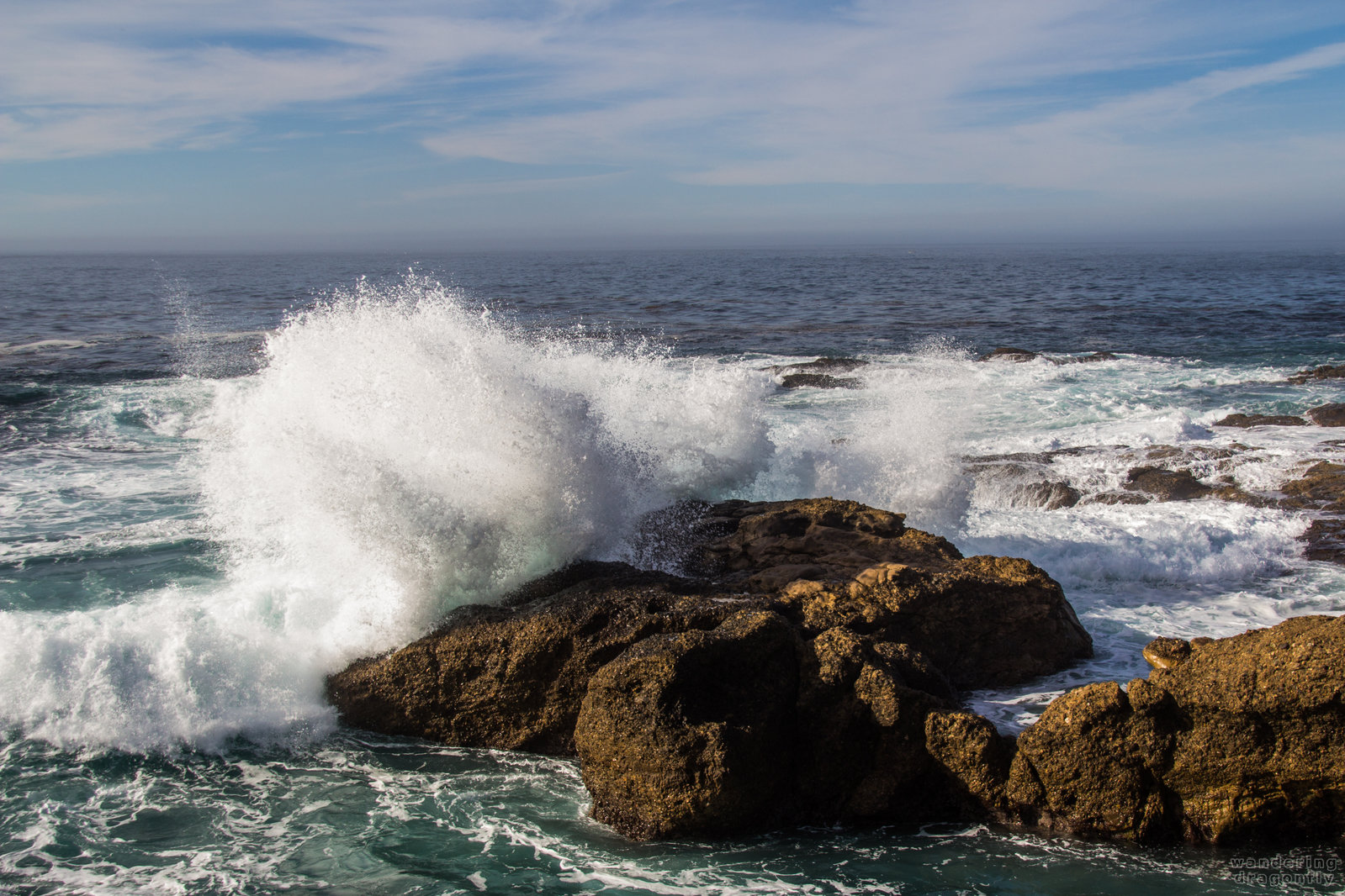 Drops of a refracted wave -- cliff, crashing wave, ocean, rock, sky, water drops