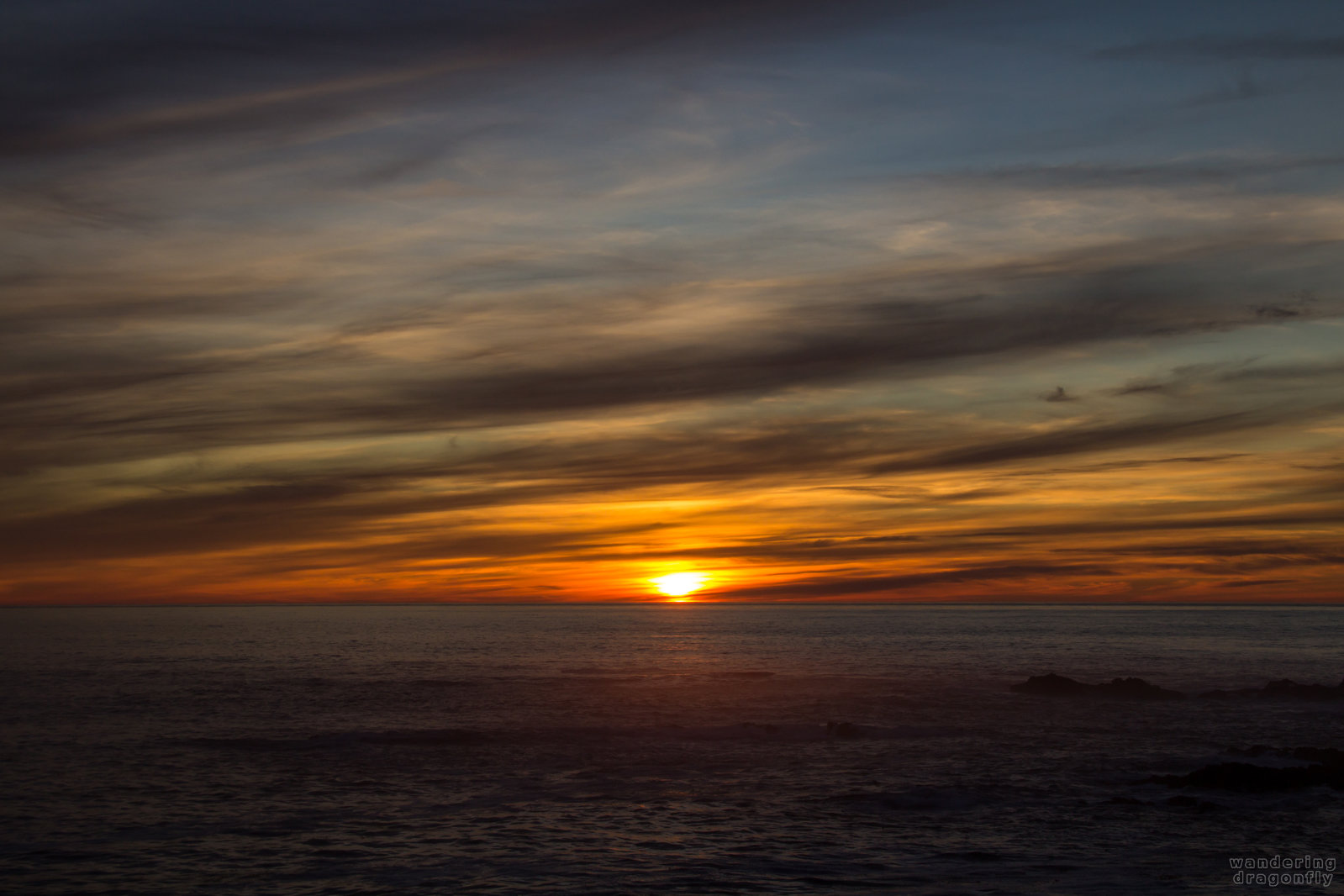 Colorful clouds -- cloud, ocean, rock, sun, sunset, water, wave