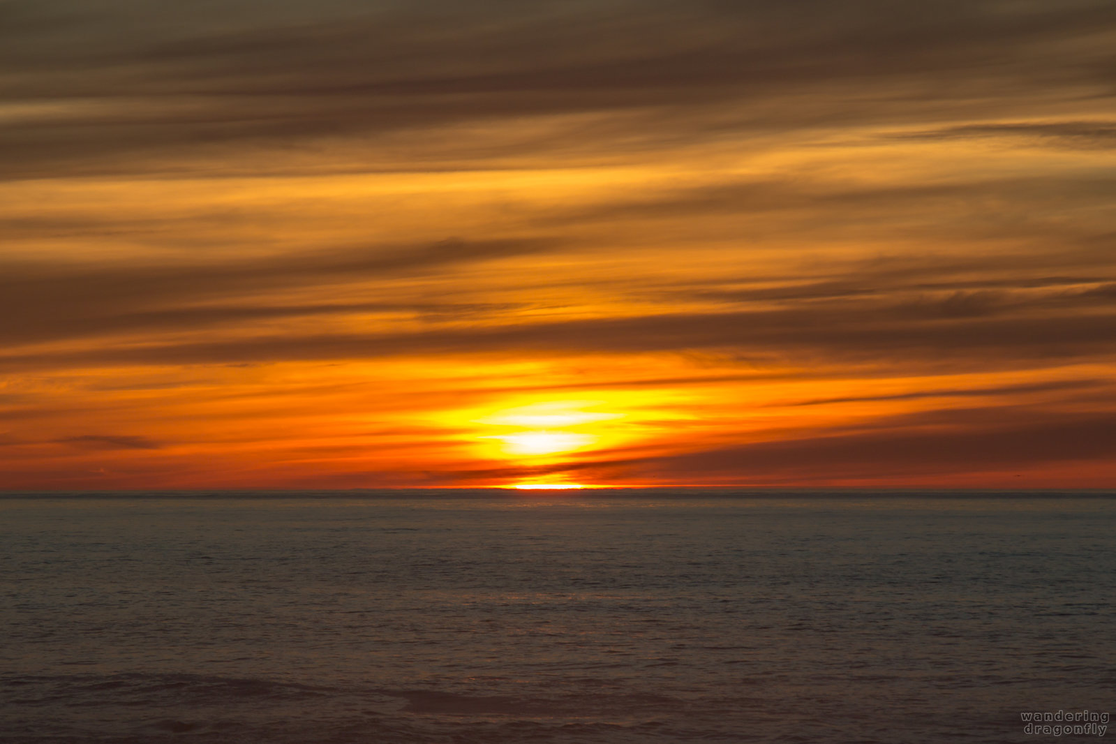 Close-up of the sun's last wink -- cloud, ocean, red, sun, sunset, water, wave