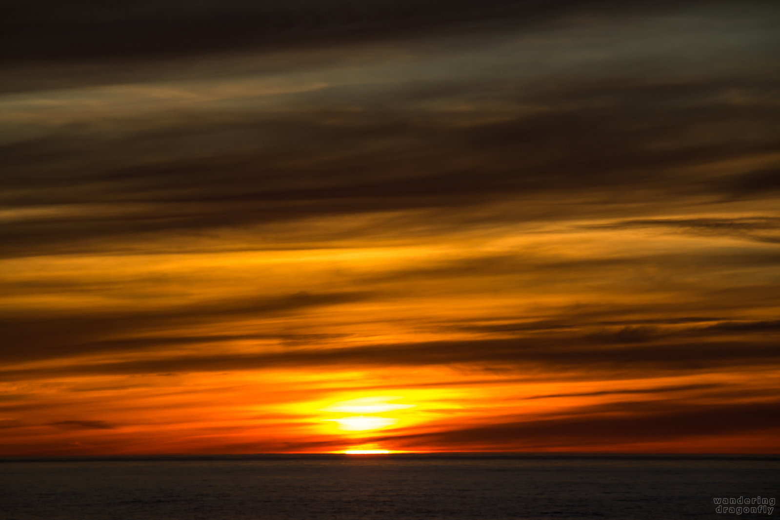 Disappearing sun -- cloud, ocean, red, sun, sunset, water