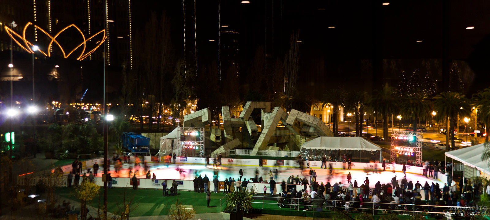 Skating rink at the Embarcadero Center with the reflection of the Tulip Flower -- christmas decoration, people, skating, skating ring
